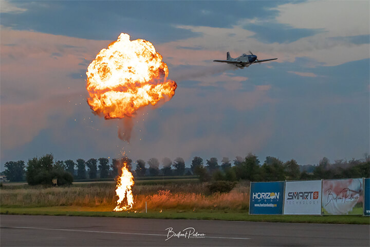 An RC warbird buzzed the runway over a small firework explosion.